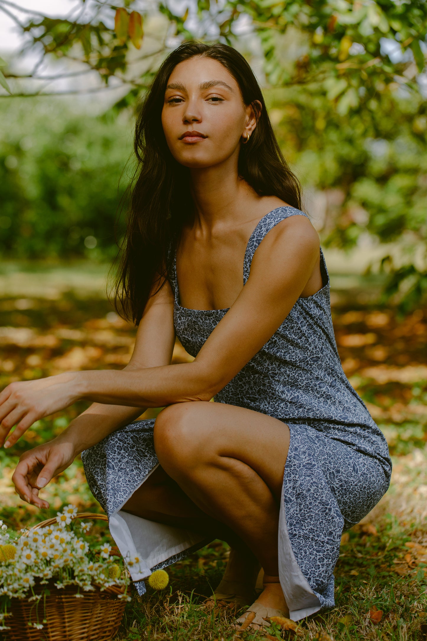 Woman crouched in a blue floral maxi dress