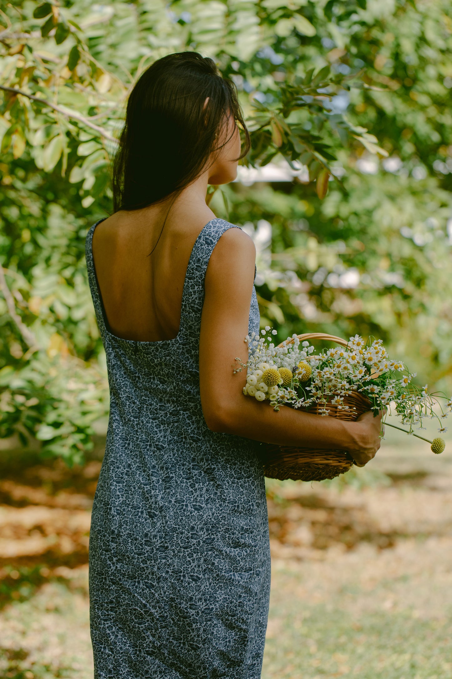 Close up back view of woman in blue floral maxi dress