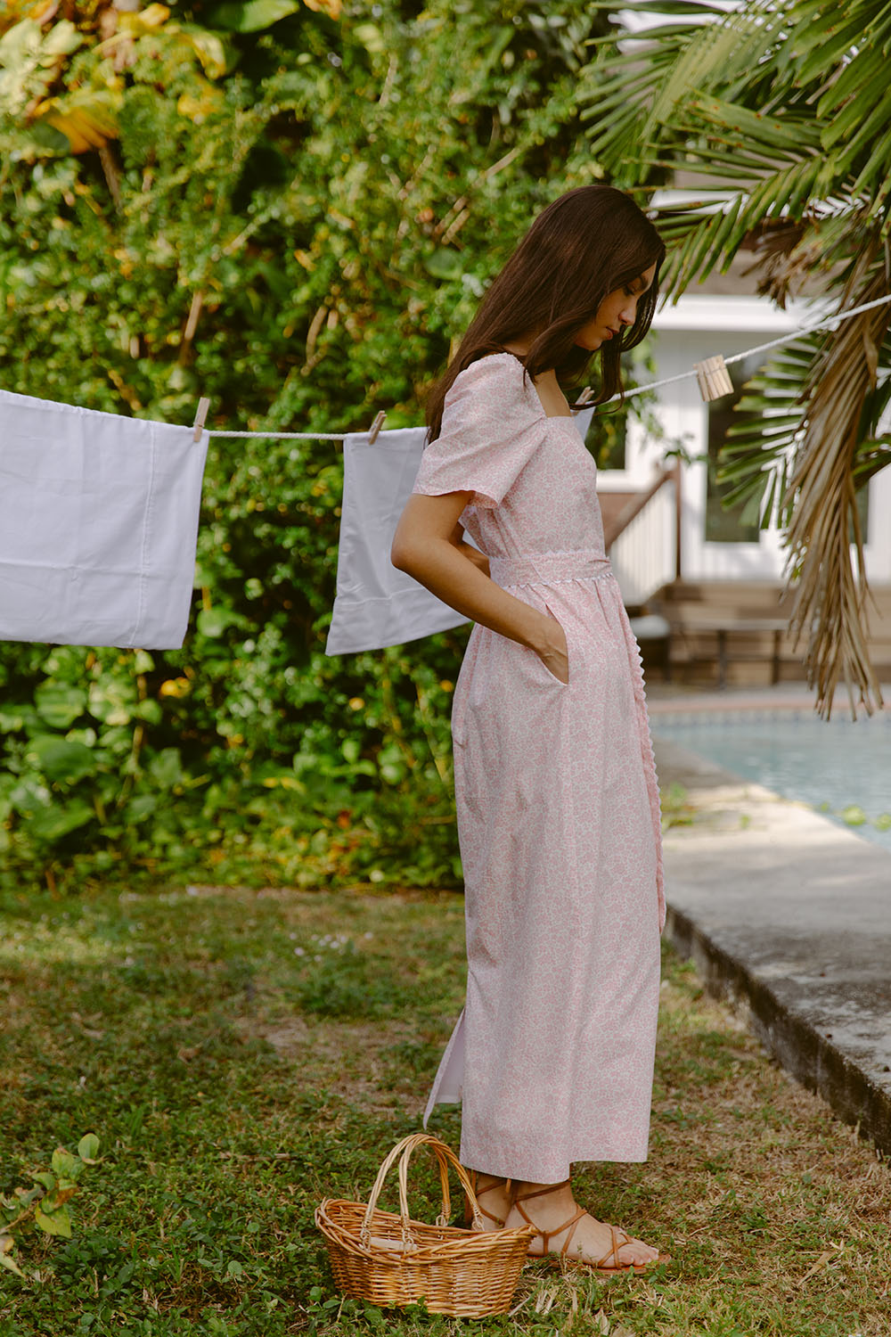 Woman wearing pink sundress by a laundry line