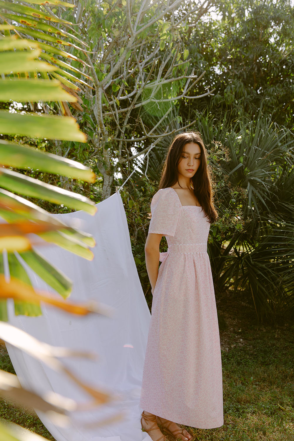 Woman wearing pink sundress by a laundry line